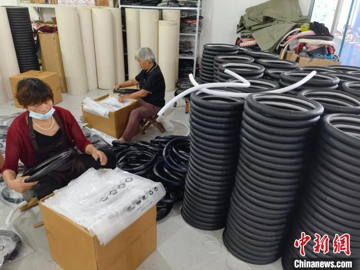 圖為村民在汽車飾品企業(yè)生產(chǎn)車間中工作?！巫雍?攝