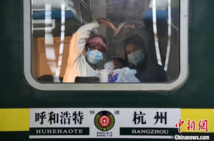 圖為登上轉(zhuǎn)運(yùn)火車的游客向額濟(jì)納比心?！⊥趵?攝