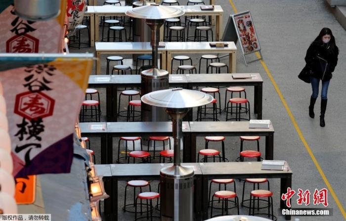 資料圖：日本東京，一名路人路過(guò)空蕩的戶外餐館。
