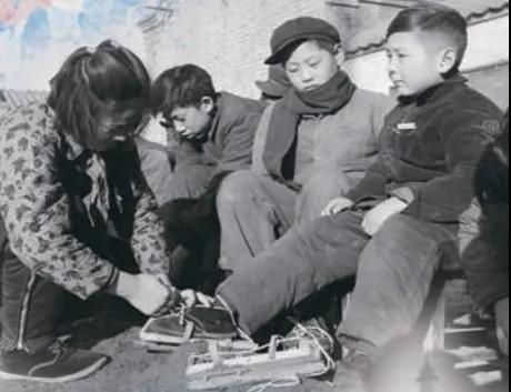上世紀(jì)50年代，孩子們?cè)诖┠景灞?圖源：北京日?qǐng)?bào))