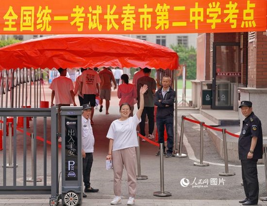 6月7日，在長春市第二中學(xué)考點，一名考生信心滿滿進(jìn)入考場，并與家長揮手致意。人民網(wǎng)記者 李洋攝