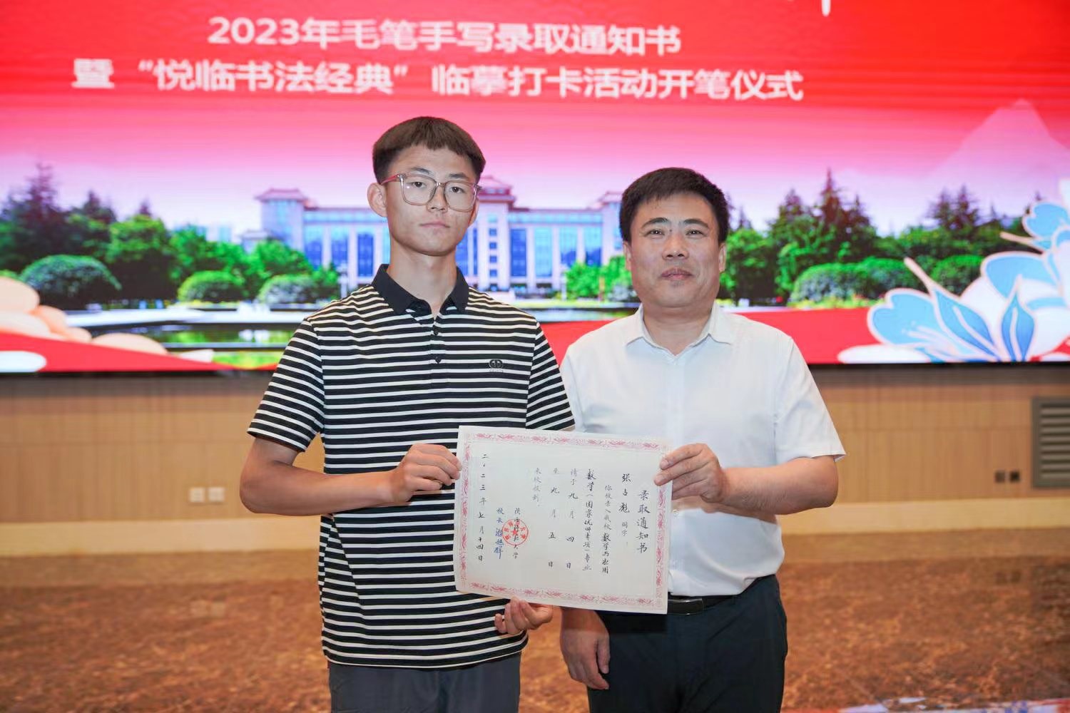 陜西師范大學(xué)黨委書記李忠軍為2023級新生代表張占彪同學(xué)發(fā)放錄取通知書。校方供圖