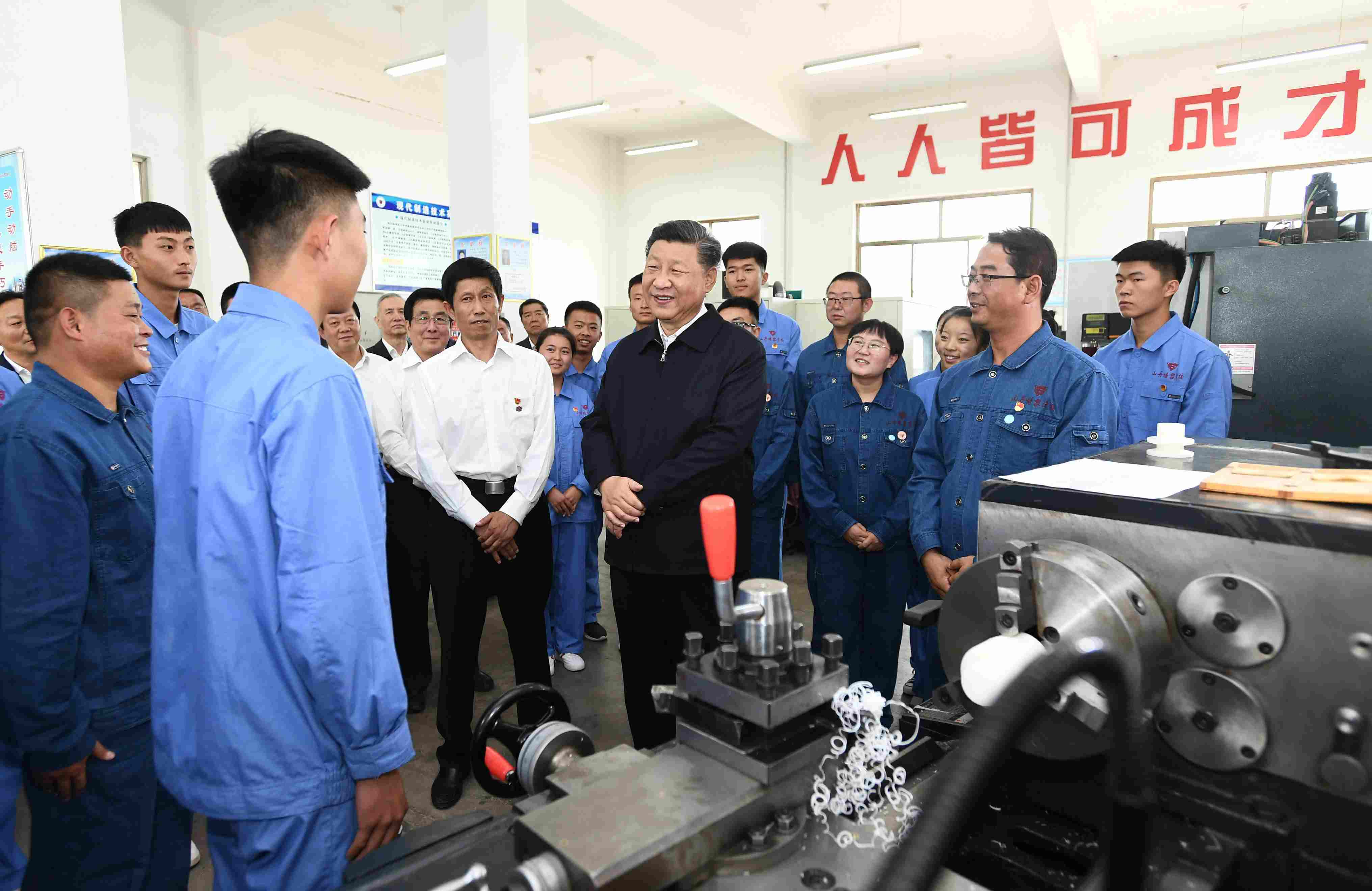2019年8月20日，習(xí)近平在甘肅省張掖市山丹培黎學(xué)?，F(xiàn)代制造技術(shù)實(shí)訓(xùn)室，觀看職業(yè)技能實(shí)訓(xùn)，同師生親切交流。