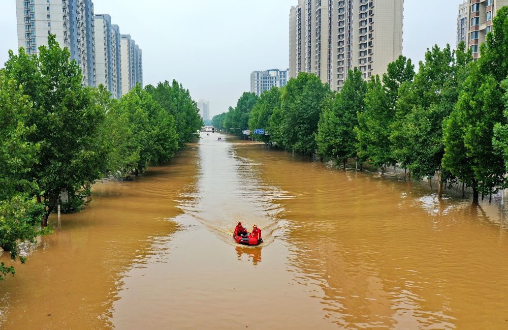 救援人員在河北省涿州市市區(qū)乘坐沖鋒舟前去轉(zhuǎn)移受災群眾（8月2日攝，無人機照片）。新華社記者 牟宇 攝