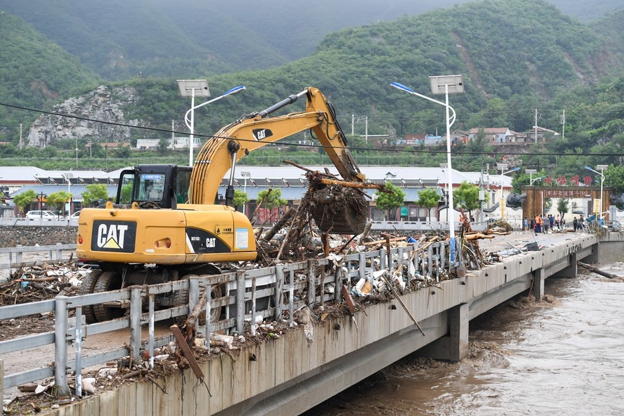 8月1日，在北京市門(mén)頭溝區(qū)水峪嘴村村口，一臺(tái)挖掘機(jī)在清理阻斷橋梁交通的雜物。目前該條道路已經(jīng)疏通完成。新華社記者 鞠煥宗 攝