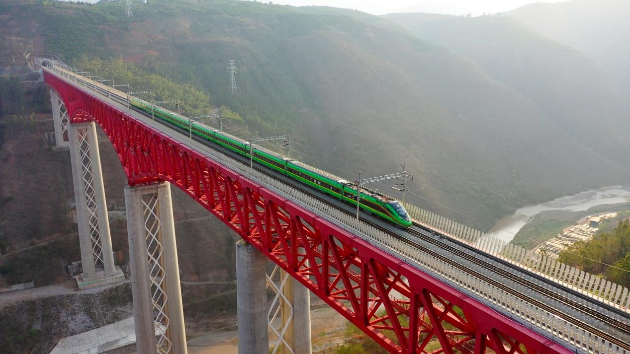 中老鐵路國際旅客列車在云南省境內(nèi)的元江特大橋上飛馳。姚巍攝