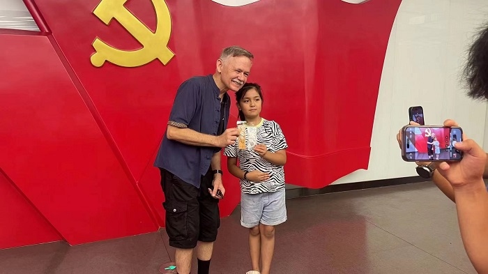 潘維廉和志愿講解員紀念合影。主辦方供圖