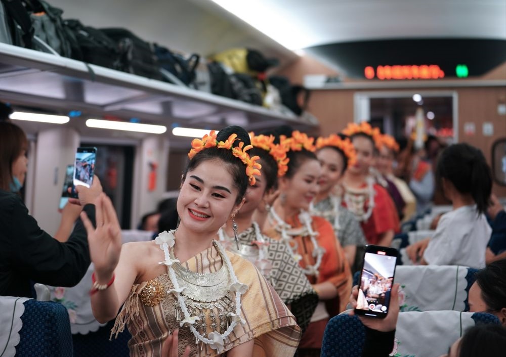 2023年4月13日，老撾工作人員在中老鐵路上開行的D887次國際旅客列車上表演。新華社記者 邢廣利 攝
