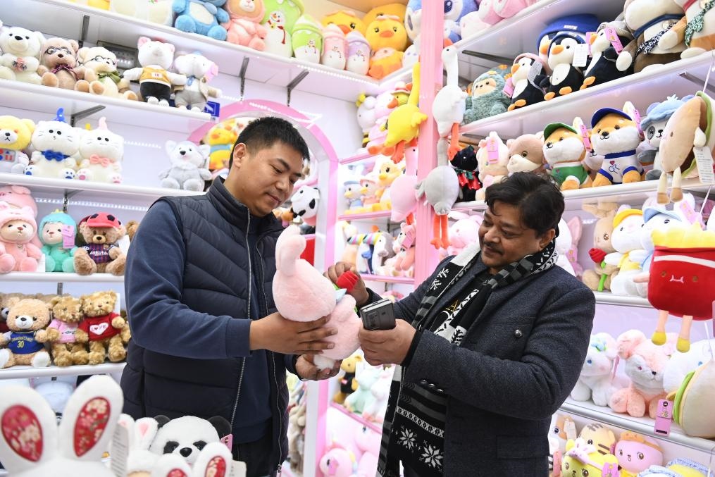 2023年2月2日，來自印度的客商（右）在義烏國際商貿(mào)城的一家玩具店鋪內(nèi)選購商品。新華社記者 黃宗治 攝