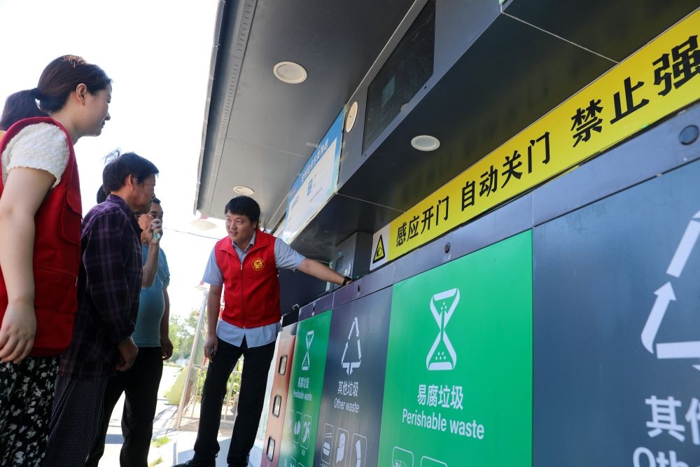 在安徽省合肥市長(zhǎng)豐縣莊墓鎮(zhèn)棗林社區(qū)，志愿者指導(dǎo)居民使用智能垃圾分類回收設(shè)備（2023年9月1日攝）。新華社記者 曹力 攝