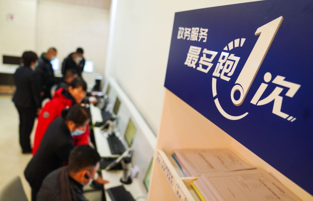 在吉林省長(zhǎng)春市二道區(qū)政務(wù)服務(wù)中心輔助填報(bào)區(qū)，市民在工作人員的輔助下進(jìn)行事項(xiàng)填報(bào)（2020年11月23日攝）。新華社記者 許暢 攝