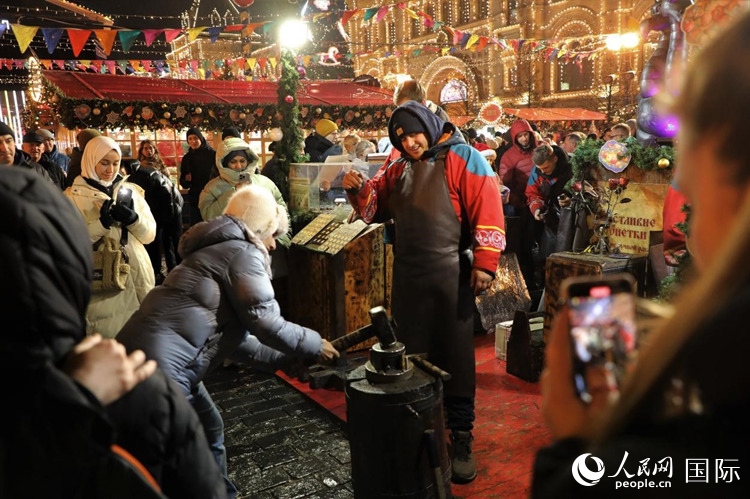 游客在新年集市上體驗(yàn)制作紀(jì)念幣。人民網(wǎng)記者 隋鑫攝