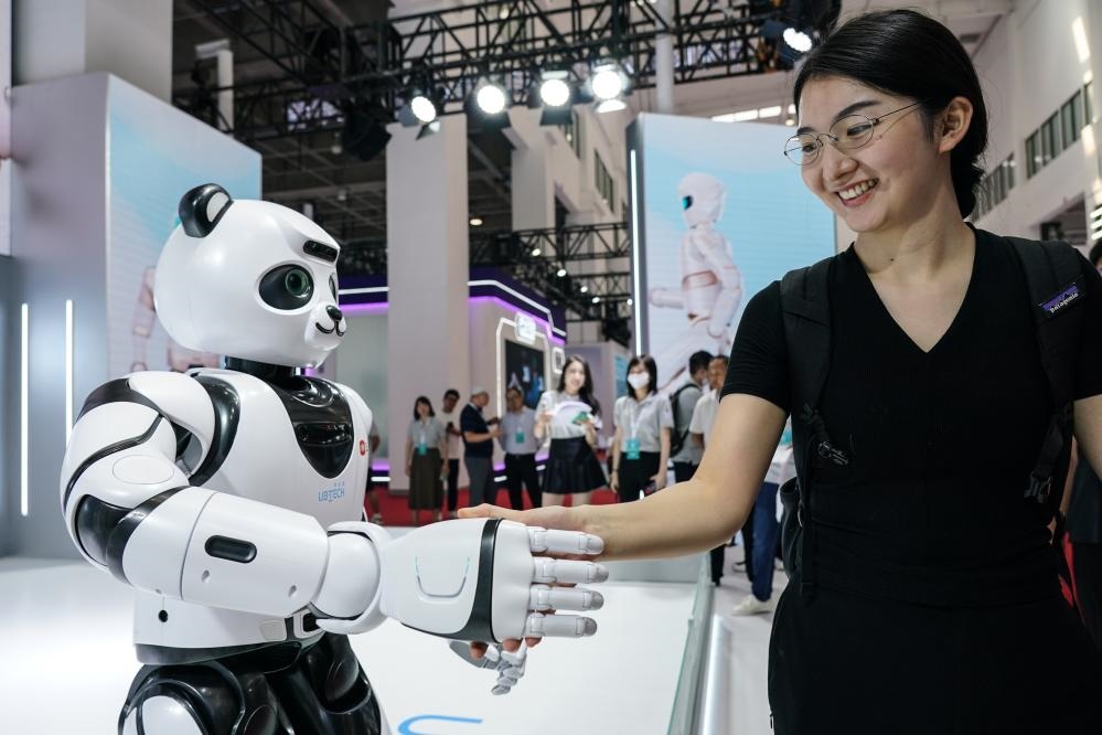 2023年8月16日，一名女士在北京舉辦的2023世界機(jī)器人大會(huì)現(xiàn)場(chǎng)與智能機(jī)器人握手。新華社記者彭子洋攝