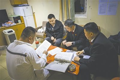 圖②：法官向船長(zhǎng)講解相關(guān)法律規(guī)定，查看船舶資料，并與船方辦理扣押船舶的手續(xù)。