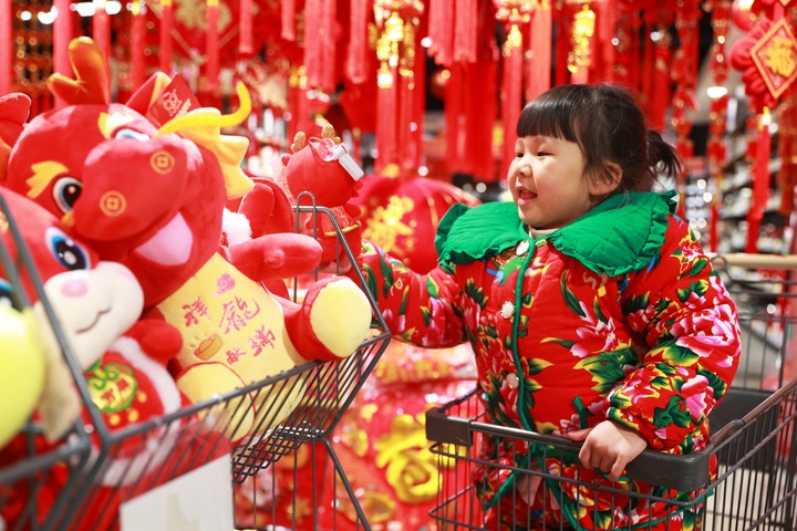 1月23日，在貴州省黔東南苗族侗族自治州岑鞏縣一家超市，小朋友在家人的帶領(lǐng)下選購(gòu)龍年毛絨玩具。新華社發(fā)（唐鵬攝）