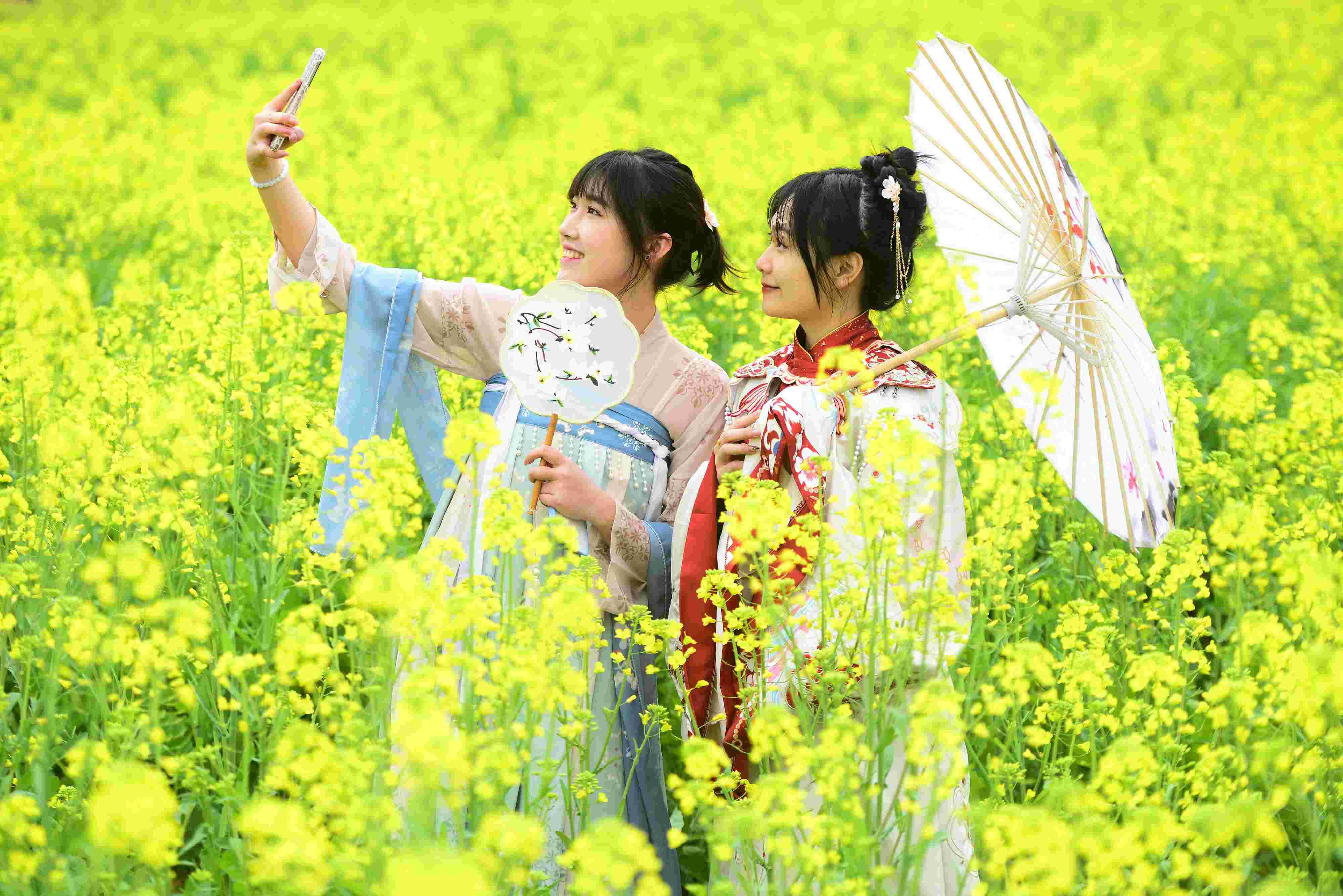 △ 2024年2月16日，廣西賀州，在富川瑤族自治縣麥嶺鎮(zhèn)三民村，游客在油菜花田間賞花拍照。