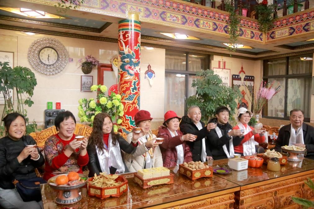 游客們?nèi)胱∶袼藓?，舉杯共飲酥油茶。新華社記者 邱星翔 攝