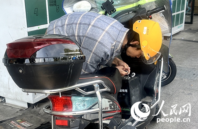 杭州一名外賣騎手正在更換共享電池。人民網(wǎng)記者 張麗瑋攝