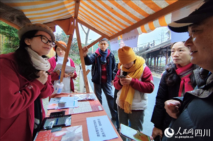 1月6日，“2024成都蒲江柑甜采摘節(jié)”上，記者見到了小萌（左一）和許多年輕人忙著做訪客接待、現(xiàn)場(chǎng)布置、票務(wù)核對(duì)、采摘服務(wù)等工作。人民網(wǎng)記者朱虹攝