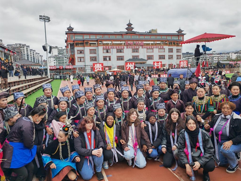 法國青年在“村超”賽場邊與參加表演的村民合影。新華社記者 羅羽 攝