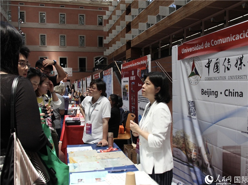 旅西華人華僑在展臺(tái)前咨詢。人民網(wǎng)記者 許海林?jǐn)z
