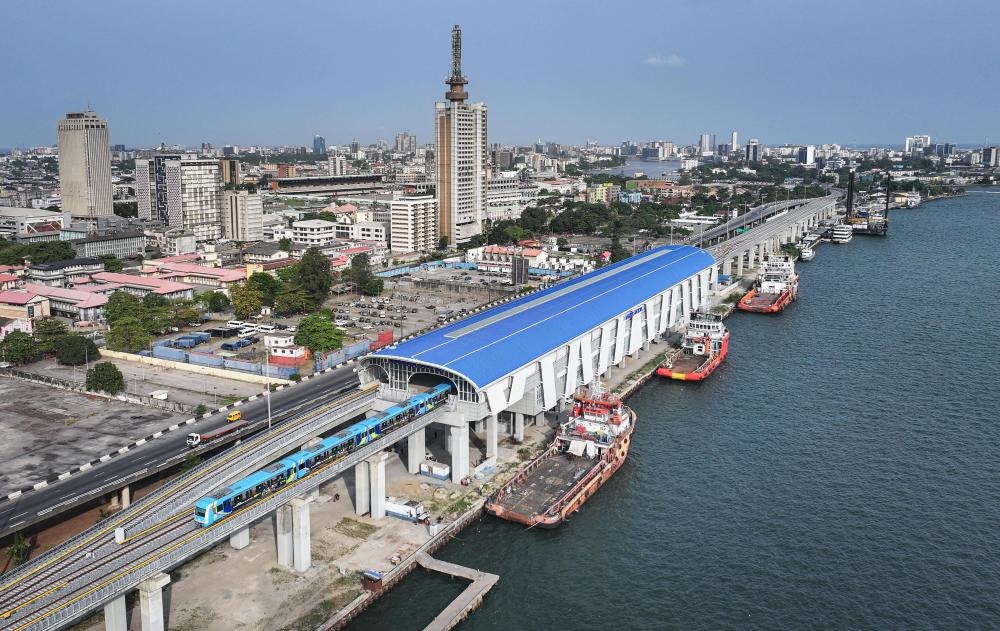2024年3月2日，在尼日利亞拉各斯，一列輕軌藍(lán)線列車駛?cè)氪a頭站（無人機(jī)照片）。拉各斯輕軌藍(lán)線是西非地區(qū)首條由中國企業(yè)自主設(shè)計(jì)、建造、施工、運(yùn)營的電氣化城市軌道交通項(xiàng)目。新華社記者 韓旭 攝