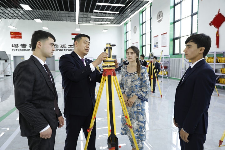 2023年4月12日，在塔吉克斯坦首都杜尚別的魯班工坊內，來自天津城市建設管理職業(yè)技術學院的老師吳正鵬（左二）向學生講解測繪儀器使用方法。新華社發(fā)（奧斯帕諾夫攝）