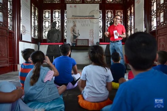 7月4日，在馬耳他桑塔露琪亞市的中國古典園林“靜園”，人們聆聽關(guān)于兵馬俑的講解。新華社發(fā)（喬納森·博格 攝）