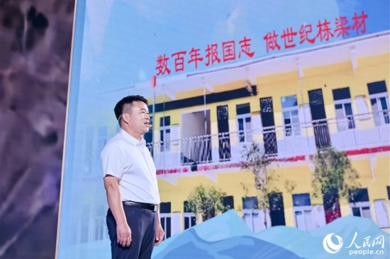 張玉滾分享用一根扁擔(dān)送孩子們走出大山的故事。人民網(wǎng)攝