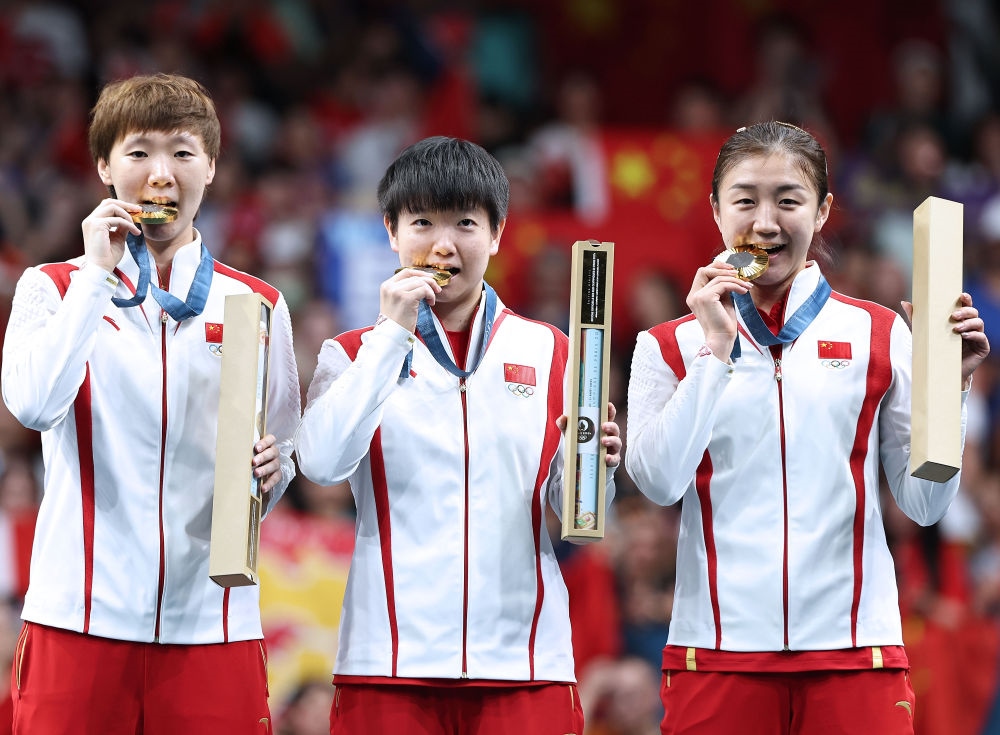 冠軍中國隊選手王曼昱、孫穎莎、陳夢（從左至右）在巴黎奧運會乒乓球女子團(tuán)體頒獎儀式上（2024年8月10日攝）。新華社記者 王東震 攝