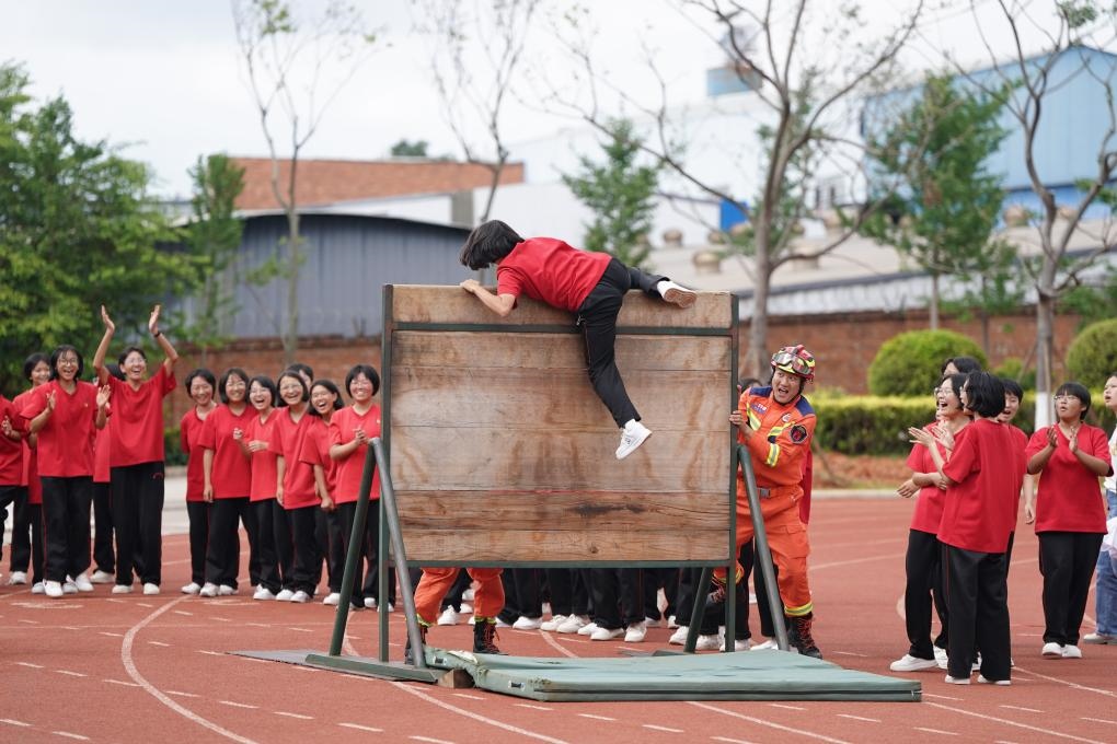云南麗江華坪女子高級(jí)中學(xué)學(xué)生在體驗(yàn)翻越障礙板。新華社記者陳欣波 攝