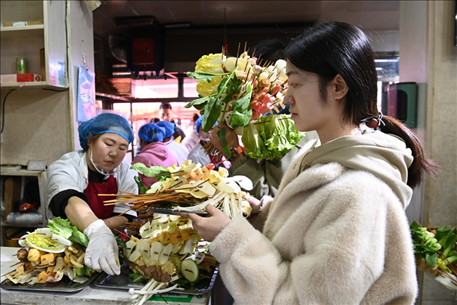游客挑選好麻辣燙菜品后排隊(duì)等待加工。新華社記者 范培珅 攝