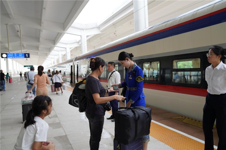 中老鐵路工作人員在站臺(tái)指引旅客進(jìn)站乘車。老中鐵路有限公司供圖