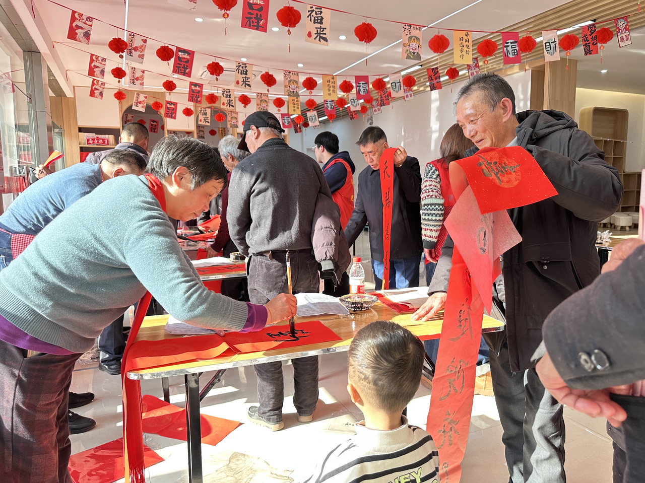 今年春節(jié)前夕，慶元縣濛洲街道同濟(jì)新村，一場送春聯(lián)活動熱鬧舉行。慶元縣融媒體中心 供圖