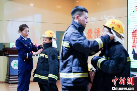圖為學(xué)生們現(xiàn)場穿戴消防頭盔和戰(zhàn)斗服。中新社記者 趙宇航 攝