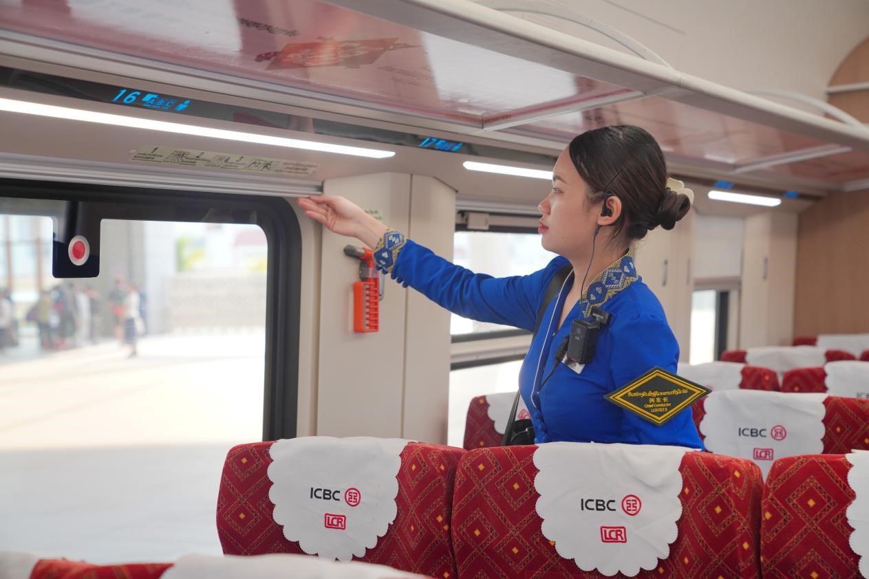 中老鐵路瀾滄號(hào)動(dòng)車組列車長(zhǎng)小麗正在進(jìn)行車廂檢查。老中鐵路有限公司供圖