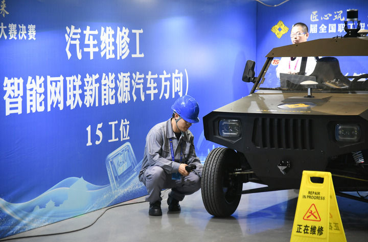 2024年9月11日，由全國(guó)總工會(huì)、人力資源和社會(huì)保障部等單位主辦的第八屆全國(guó)職工職業(yè)技能大賽決賽在陜西開(kāi)幕。這是選手在位于西安國(guó)際會(huì)展中心的比賽場(chǎng)地參加汽車維修工（智能網(wǎng)聯(lián)新能源汽車方向）工種比賽。新華社記者 張博文 攝