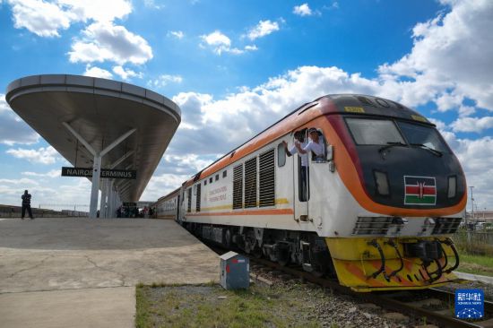 5月31日，在蒙內(nèi)鐵路內(nèi)羅畢站，機(jī)車駕駛員蔣立平（右）和博爾在即將開(kāi)往蒙巴薩的E2次列車上揮手致意。新華社記者 楊光 攝